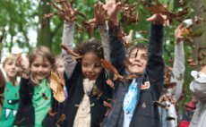 Leerlingen van het Stedelijk Basisonderwijs gooien met herfstbladeren