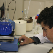 Een jongen onderzoekt een chemische stof in een lab.
